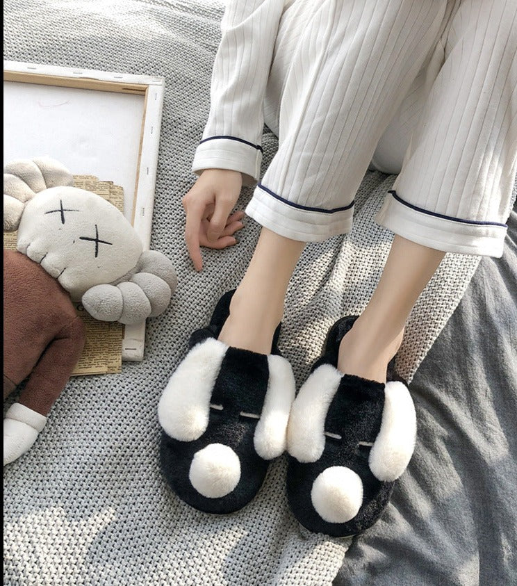 Image of a person wearing Dalmatian slippers in black