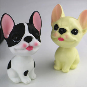 Image of two smiling frenchie bobbleheads in the color cream and pied black and white