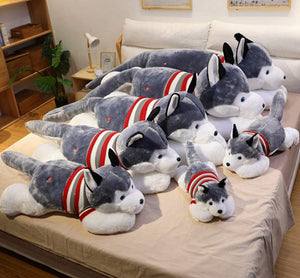 Image of eight super cute and realistic Husky stuffed animal plush toys in different sizes lying on the bed