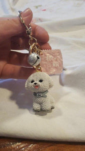 Image of a lady holding a white bichon frise keychain
