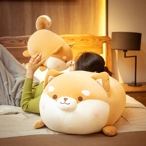 Image of a lady sitting on the bed with two super cute Shiba Inu plush pillow stuffed animals and kissing the one - close mouth Shiba Inu design
