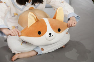 Image of a girl on the bed holding a Corgi stuffed animal by his ears