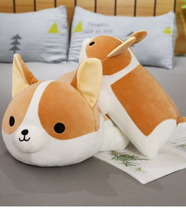 Image of two Corgi stuffed animals soft plush toys on one another lying on the bed