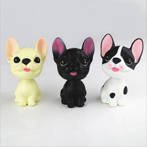 Image of three smiling french bulldog bobbleheads in the color black, cream, and pied black and white