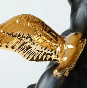 Close up image of a black french bulldog statue gold-plated angel wings