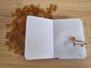 image of dachshund paperclips in use on a notebook