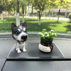 Image of a standing husky bobblehead on car dashboard