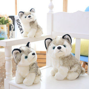 Image of three super cute Husky stuffed animal plush toys in different sizes sitting on a white bench
