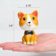 Image of a nodding Corgi bobblehead on the hand of a person
