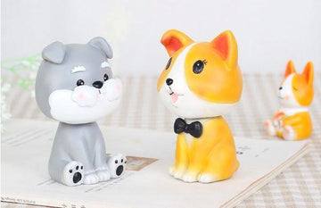 Image of two nodding bobbleheads shaped like a Miniature Schnauzer and a Corgi