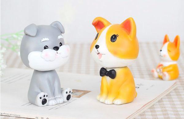 Image of two nodding bobbleheads shaped like a Miniature Schnauzer and a Corgi