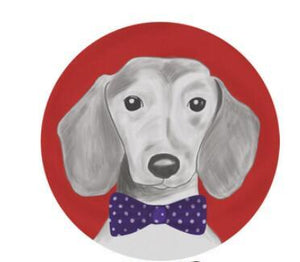 Image of a well-dressed Dachshund rug in a blue and white polka-dotted bow-tie on a circular red background