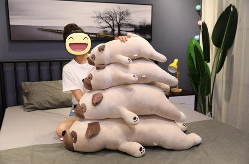 Image of a girl on the bed next to four Pug stuffed animals soft plush toys in different sizes
