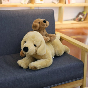 image of a light brown and dark brown labrador stuffed animal plush toy sleeping on a couch