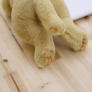 image of a light brown labrador stuffed animal plush toy sleeping on a table - backview