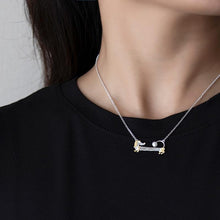 Load image into Gallery viewer, Image of a girl wearing a dachshund dog necklace with a real freshwater pearl pendant design