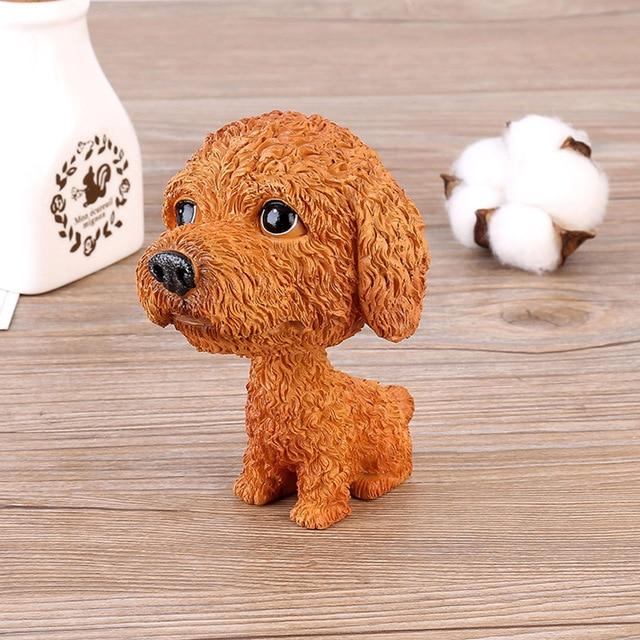 Image of a Toy Poodle bobblehead sitting on the floor