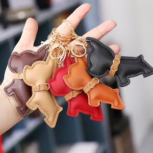 Image of five frenchie keychains in the hand of a person in different colors