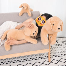 Load image into Gallery viewer, A person lying on a gray sofa with three large plush golden retriever puppy toys in a home setting. The person's face is obscured by a yellow emoji sticker, and the background includes a patterned rug.