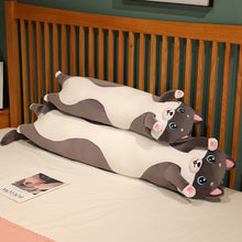 Load image into Gallery viewer, Two long plush husky-shaped pillows in a gray and white color scheme, arranged stacked on a white bed in front of a wooden slatted headboard.