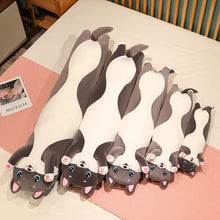 Load image into Gallery viewer, Five gray and white husky-shaped plush pillows of different sizes arranged on a bed with pink mats.