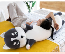 Load image into Gallery viewer, Image of a lady lying on the bed on a life size Husky stuffed animal plush toy pillow