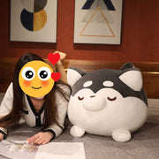 Image of a girl sitting on the bed with her black Husky Stuffed Animal Plush Toy Pillow