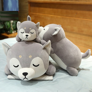 Image of three sleeping Siberian Husky stuffed animal plush toy pillows in different sizes kept on the bed