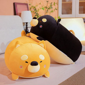 Image of an orange and black color sleeping Shiba Inu plush toy pillows kept on the bed
