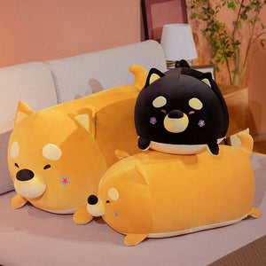 Image of three realistic Shiba Inu stuffed animal plush toy pillows in the color orange and black in different sizes kept on the bed