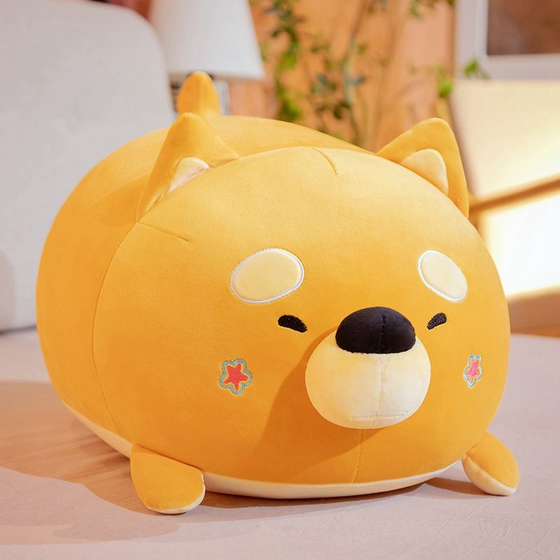 Image of an orange color sleeping Shiba Inu stuffed animal plush toy pillow kept on the bed