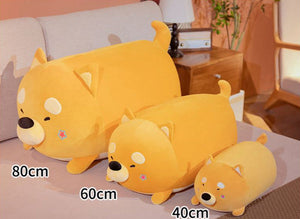Image of three sleeping Shiba Inu stuffed animal plush toy pillows in different sizes lying on the bed