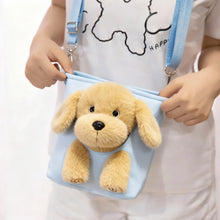Load image into Gallery viewer, Child holding a blue bag with a plush dog toy hanging out, wearing a white shirt with black text.