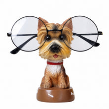 Load image into Gallery viewer, A decorative figurine of a small tan and white dog wearing oversized round black-framed eyeglasses, sitting on a brown base against a plain white background.