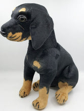 Load image into Gallery viewer, image of an adorable rottweiler stuffed animal plush toy on a table-sideview
