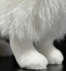 image of an adorable white samoyed stuffed animal plush toy in black background - feet