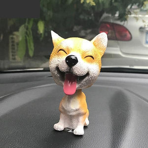 Image of a smiling Shiba Inu bobblehead on a car dashboard