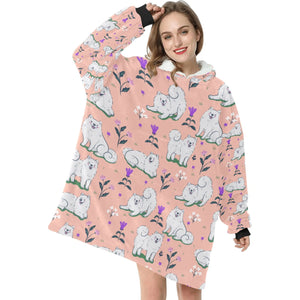 Image of a lady wearing an American Eskimo Dog blanket hoodie for women in peach color