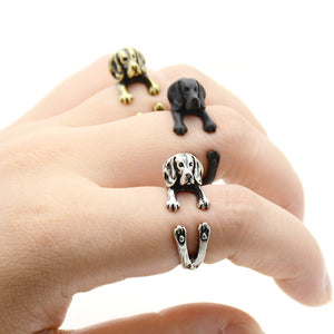 Image of three finger wrap Beagle rings on the finger of a person in three colors including Antique Silver, Bronze, and Black Gunmetal