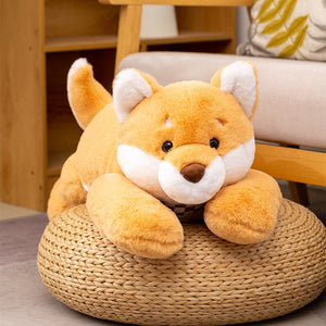 This image  shows an adorable Shiba Inu Stuffed Animal sitting on a jute table.