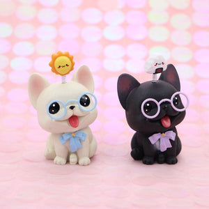 Image of two smiling french bulldog bobbleheads in the color white and black