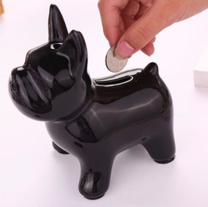 Image of a person putting money in french bulldog piggy bank in the color black