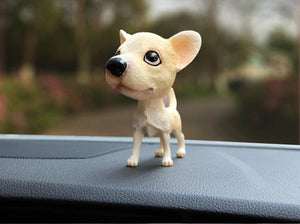 Image of a chihuahua bobblehead in a car