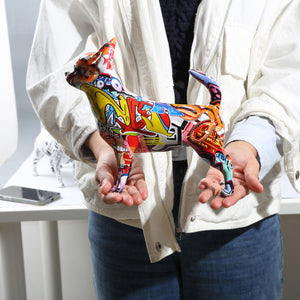 Image of a lady holding multicolor graffiti design Chihuahua statue in her hand