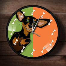 Load image into Gallery viewer, Image of a metal and glass frame black and tan Chihuahua wall clock with an adorable Chihuahua with bones design