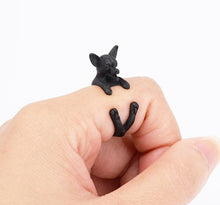 Load image into Gallery viewer, Image of a finger wrap smiling Chihuahua ring on the finger of a person in the color Black Gun