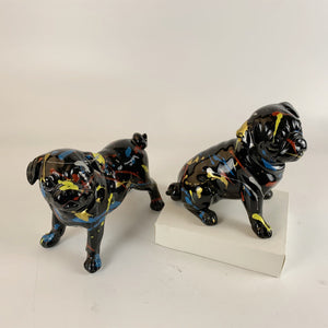 Image of a standing and sitting black pug statues