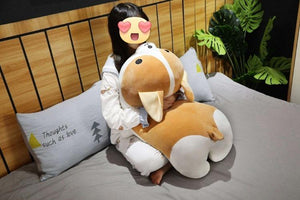 Image of a girl sitting on the bed holding a Corgi stuffed animal soft plush toy