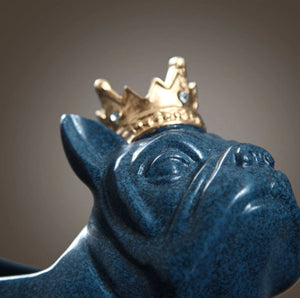 Close up image of a french bulldog statue in blue wearing a gold crown
