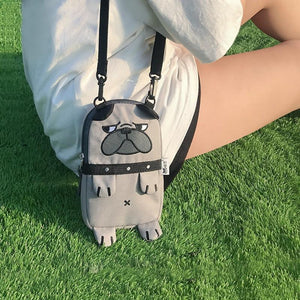Image of a super-cute English Bulldog bag with a cutest Bulldog print in the color Khaki carried by a girl sitting on grass